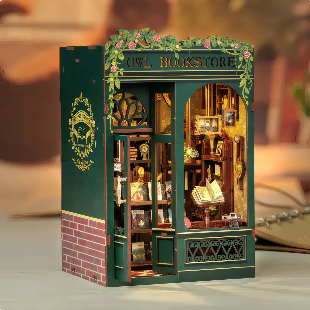 Maquette DIY Owl Bookstore – book nook miniature avec façade verte et détails floraux, idéale pour la décoration de bibliothèque ou de bureau.
